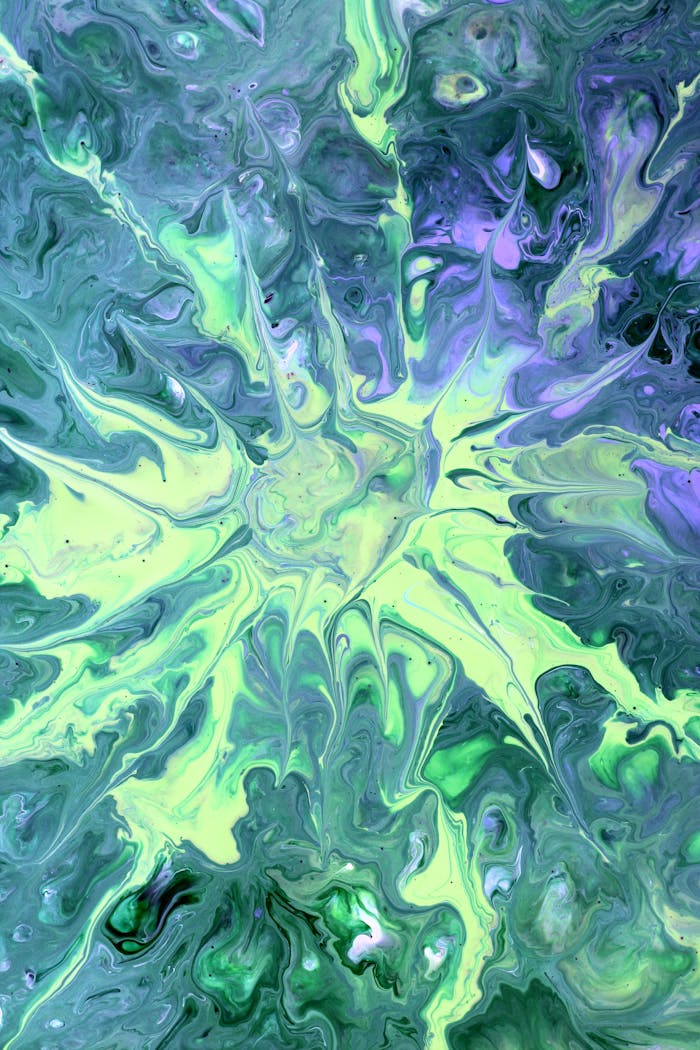 Colorful abstract fluid art with green and purple swirls, resembling a starburst pattern.